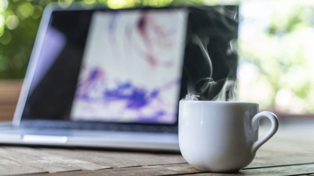 Stomende kop koffie met laptop