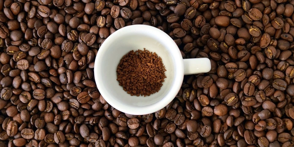 Kopje met instant coffee, omringd met koffiebonen