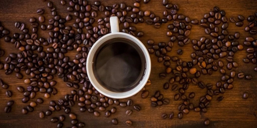 Kopje koffie omringd met koffiebonen