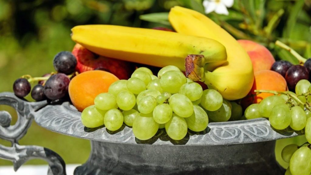Fruitschaal met bananen, druiven en perzik
