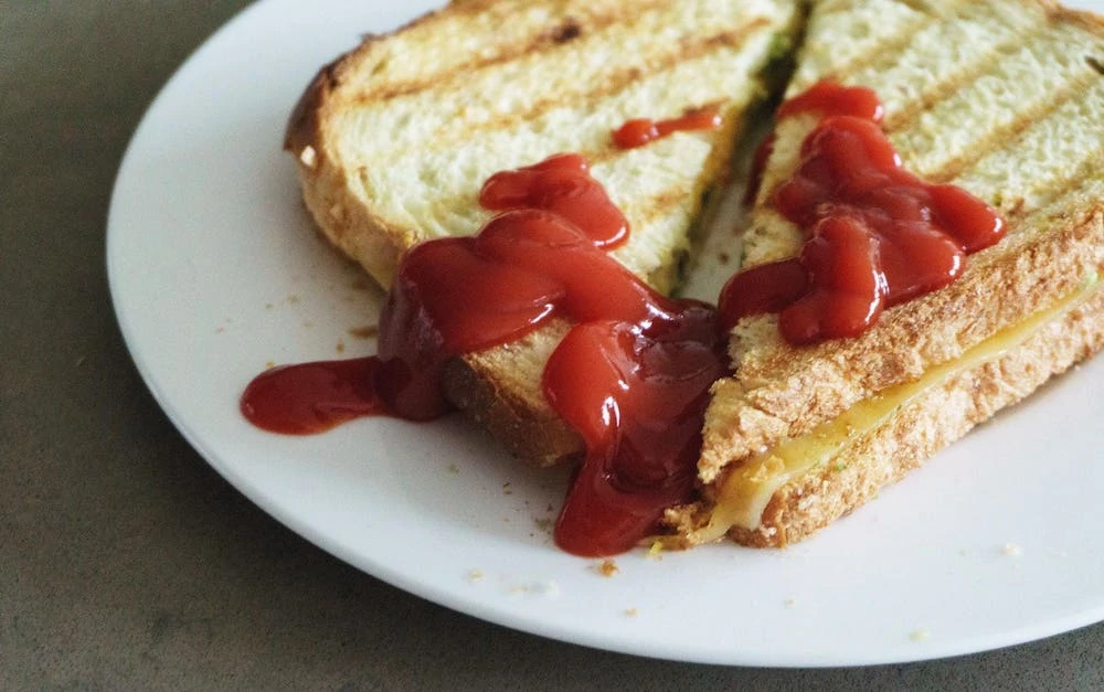 tosti met ketchup op een wit bord