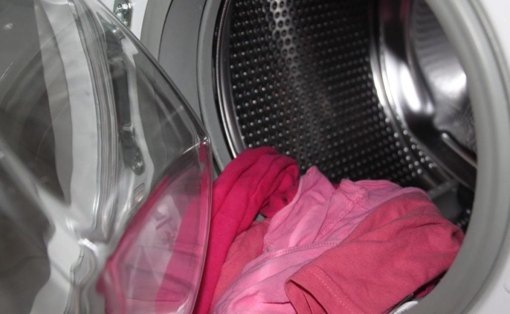 wasmachine met roze kleding erin