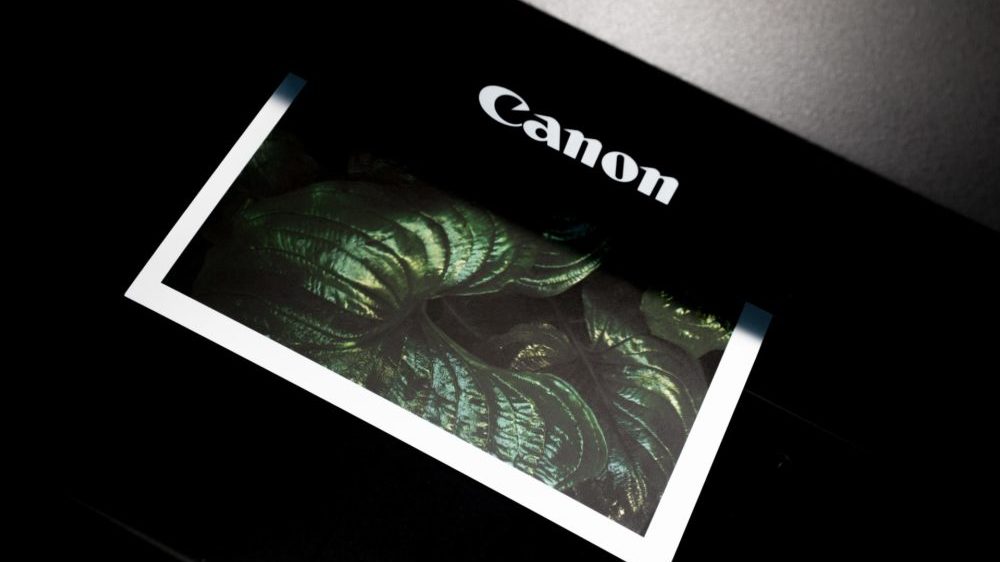 Een Canon printer waar een foto uit komt.