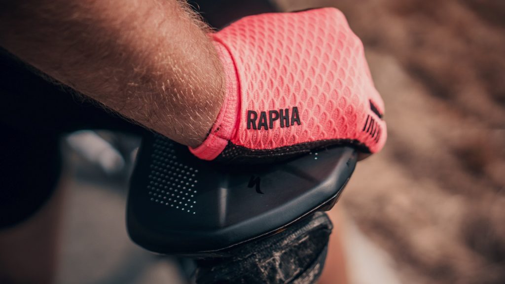 Roze fitness handschoen leunend op een zwart fietszadel