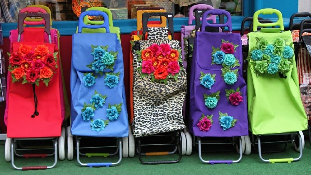 Vooraanzicht van boodschappentrolleys in verschillende kleuren met bloemen.