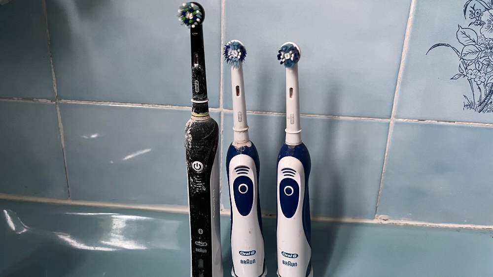 Drie elektrische tandenborstels op blauwe achtergrond, vooraanzicht
