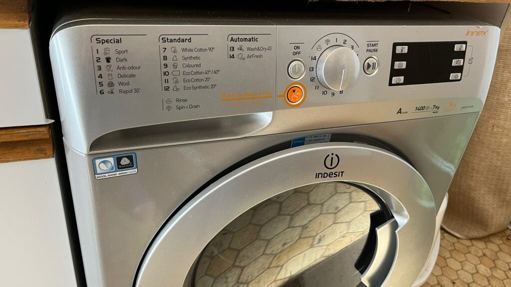 Grijze wasmachine met focus op het bedieningspaneel, vooraanzicht